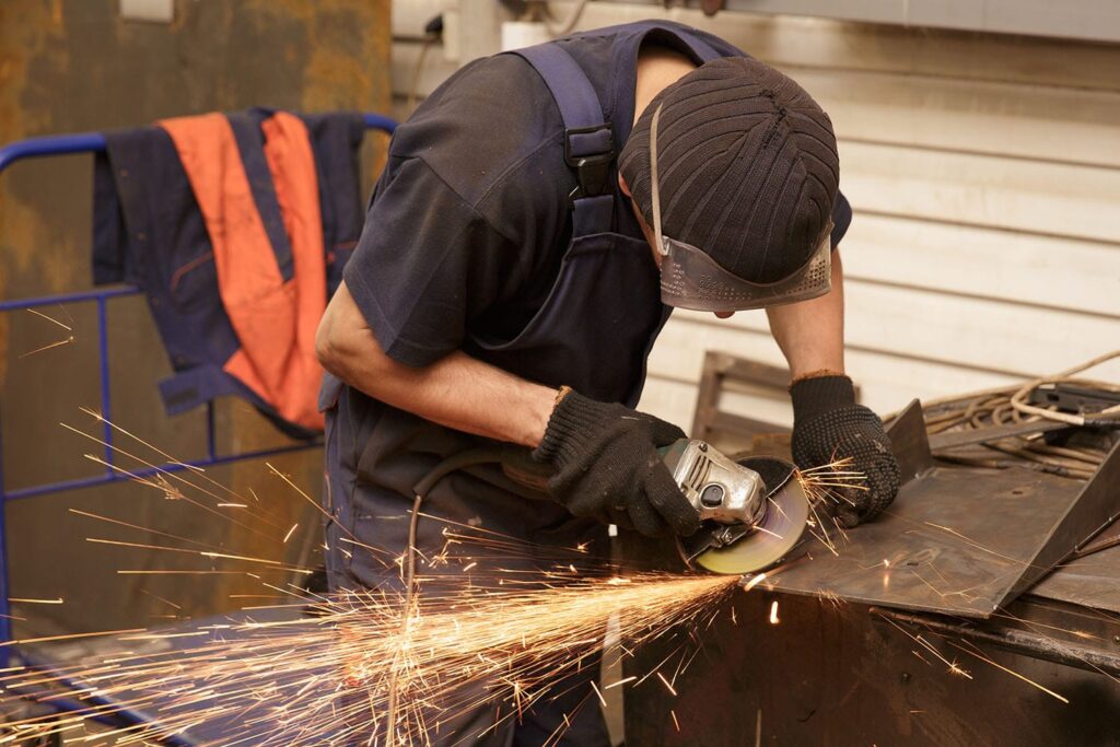 Apprentice shaving extra length off metal cutting